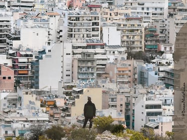 a person standing on a hill with a full city buildings in the background