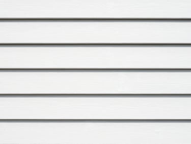 Close-up of the same exterior wood siding, now perfectly sanded, primed, and painted with crisp white coastal-grade paint, clean lines