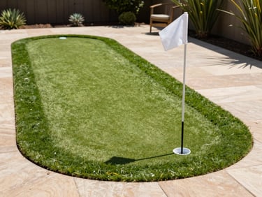 A pristine custom backyard putting green with a clean cup and flag, bright natural sunlight, sharp focus