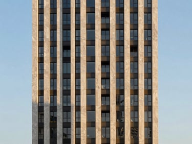 Monolithic high-rise tower facade capturing the high-contrast afternoon sun, sharp angles against a clear sky.