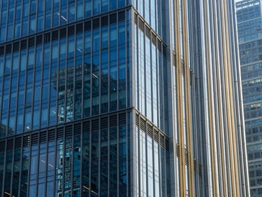 Architectural lines of a modern financial district skyscraper, deep blue glass reflecting daylight, crisp geometric composition
