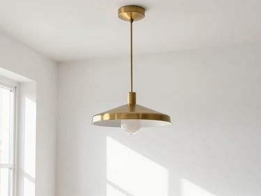 Bright architectural photography, a modern minimalist brass pendant light hanging in a sun-drenched room with white walls, soft natural daylight, 35mm