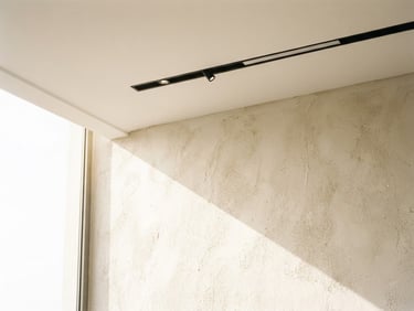 Bright architectural photography of a sun-drenched modern interior in Mosul, featuring minimalist linear ceiling light fixtures casting soft natural daylight onto textured plaster walls, 35mm, sharp macro detail.