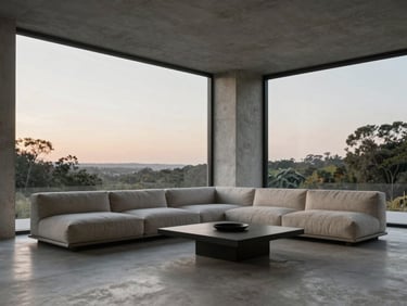 Minimalist residential lounge with floor-to-ceiling windows, soft twilight light on textured concrete and linen.