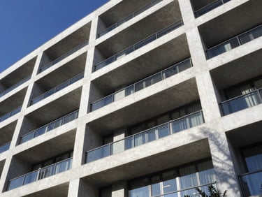 Geometric facade of a modern luxury residential building in Monterrey, sharp concrete angles, bright mid-day sun