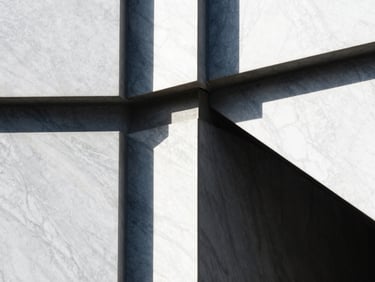 Tight abstract detail of premium white marble and dark concrete joints, sharp architectural shadows, high-contrast sunlight, editorial style