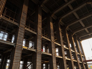Wide angle interior of a historic building undergoing structural steel reinforcement, dramatic high-contrast lighting