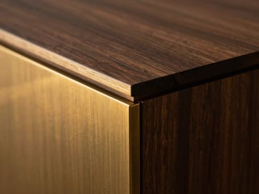 Extreme macro detail of a pristine material transition where dark walnut wood meets brushed brass, sharp focus