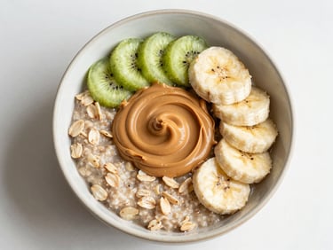 Top-down food photography of warm oatmeal in a ceramic bowl, thick peanut butter swirl, banana slices, soft morning light