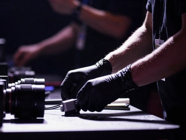 Close-up of a medic's hands in black gloves, preparing equipment on a table backstage, subtle stage lighting, high-contrast, 35mm lens