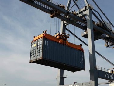 Low-angle shot of a massive port crane lifting a shipping container at Lázaro Cárdenas terminal, dramatic natural light, industrial scale