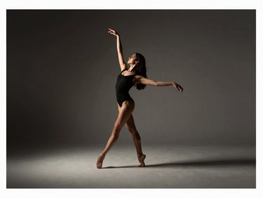 Elegant editorial dance photography, dramatic side-lit studio light, Victoria Holanda in mid-movement, sharp focus, 35mm, wide landscape crop with generous negative space