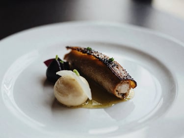 Exquisite close-up of a gourmet dish, artfully plated, refined lighting, elegant editorial photography, high-contrast, shallow depth of field, 35mm film texture