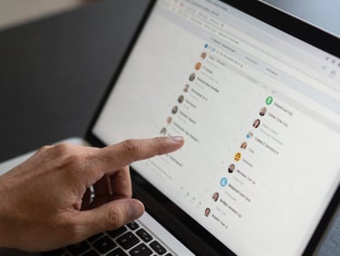 Close-up overhead shot of a hand navigating a CRM lead pipeline on a laptop screen, organized rows of contact records visible, even north-facing daylight, clean dark desk surface, no clutter, interface details sharp at macro scale