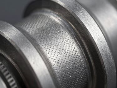 Macro shot of a textured stainless steel automotive component, precise micro-etched surface pattern, cool metallic reflection.