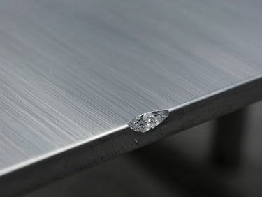 Macro shot of a chemical milling process, clean acid-etched edge of a steel sheet, no thermal deformation, precise metallurgy.