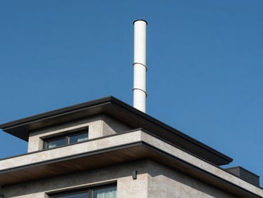 Low-angle architectural shot looking up at a modern luxury villa roofline with a white spiral turbine seamlessly integrated, bright crisp daylight, sharp shadows, deep blue sky.
