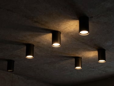 Architectural low-key lighting fixtures on a concrete ceiling, dramatic shadows and yellow glows