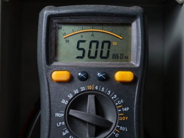 Professional digital multimeter displaying precise voltage readings on a dark electrical panel, high contrast