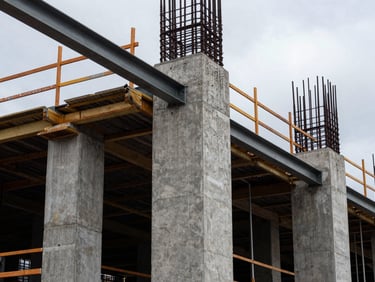 Close-up detail of reinforced concrete pillars and steel beams at an active metropolitan construction site, overcast daylight.