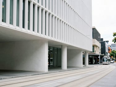 Modern architectural detail of Melbourne streetscape, clean lines, soft overcast lighting, tram tracks curving elegantly, minimalist perspective