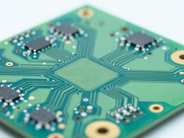 Macro close-up of a high-density printed circuit board with clean green solder mask and gold-plated pads, bright clean-room lighting.