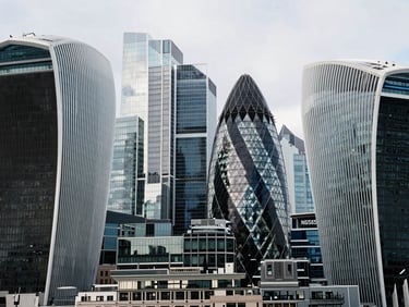 High-angle architectural shot of London financial district, sharp glass skyscrapers reflecting cool overcast daylight, structured steel frames, 35mm