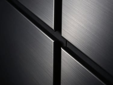 Close-up of brushed silver metal texture with sharp architectural lines, moody low-key lighting, high contrast