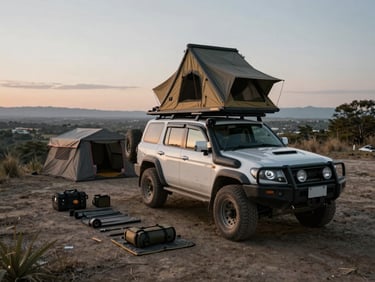 Overhead shot of an overlanding camp at first light — a rooftop tent mounted on a 4x4 with a trail-side ridge behind it, ground kit laid out methodically, flat grey dawn light, dust still visible on the vehicle panels, no people in frame