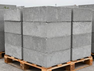 Fly ash concrete blocks stacked on a wooden pallet, smooth grey industrial finish, sharp focus, 35mm
