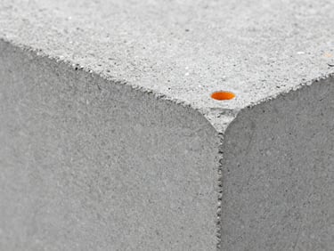 Macro close-up of concrete block textures showing aggregate density, sharp focus, cool concrete greys, 35mm