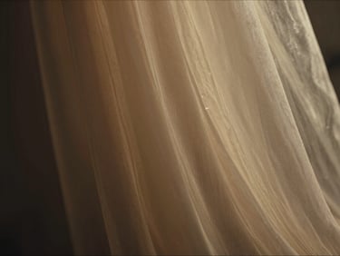 Extreme close-up of sheer fabric in motion, desaturated warm tones with deep shadow on left edge, a sliver of stylized amber light cutting diagonally across the textile — cinematic 2.39:1 crop, no figure, pure texture and color grading