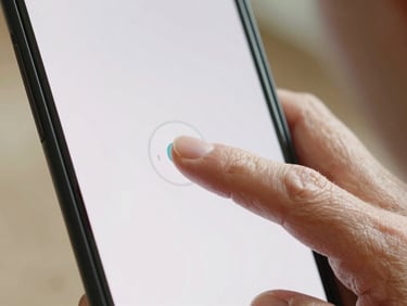 Close-up of a senior hand pressing a large, clearly labeled button on a simplified smartphone interface, natural daylight.