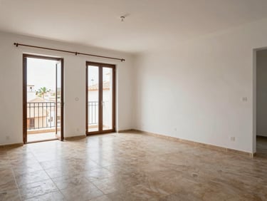 Wide shot of a fully renovated living room in a Cádiz apartment—new tiled floor, freshly painted walls, natural light from a balcony door, no people, real end-result documentary style