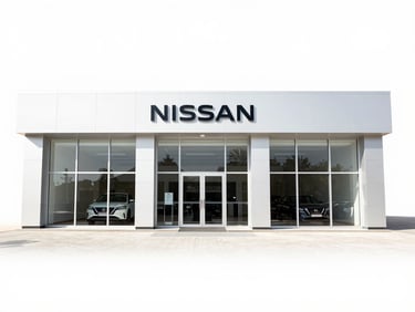 Modern Nissan dealership exterior in Riyadh, bright sunny day, clean architecture, no people, wide shot