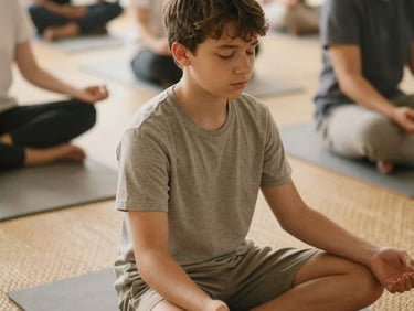 A close-up candid photograph of a teenager sitting cross-legged on a woven mat, eyes closed in quiet focus during a mindfulness workshop, soft warm light, 35mm.