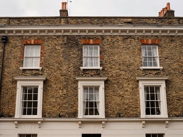 Straight-on architectural elevation of a classic Edwardian terrace house in Barnet with freshly installed timber-alternative sash windows, warm editorial photography, soft natural overcast daylight, rich heritage tones, 35mm