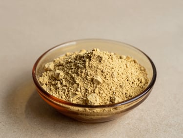Minimalist shot of raw yellow maca root powder in a clean amber glass dish, warm natural light, shallow depth of field, 35mm