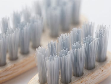 Macro shot of compostable toothbrush bristles, natural texture, cool lighting, sharp focus.