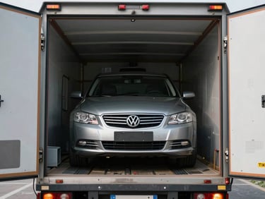A clean, enclosed car carrier truck with the rear door open, showcasing a secured sedan parked safely inside.
