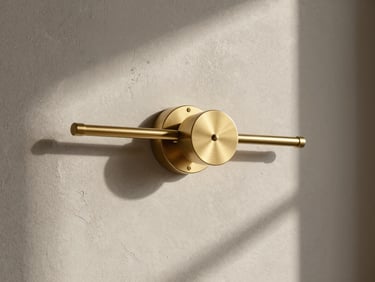 Elegant interior vignette showing a custom brushed brass light fixture against a textured plaster wall, minimalist design