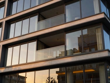 Architectural detail of a modern building balcony at sunset, golden reflections on glass, 35mm
