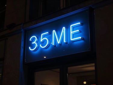 Dramatic night-time architectural photography of a glowing electric blue 3D acrylic storefront sign, deep shadows, high-contrast, 35mm lens