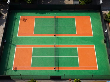 Top-down architectural grid of a professional pickleball court layout, painted in electric green and high-visibility orange, crisp stadium floodlights casting sharp lines.