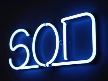 Custom LED neon sign glowing with blue light in a modern retail interior, dramatic contrast, 50mm lens