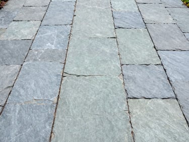 Symmetrical overhead shot of a newly laid slate garden terrace with perfect drainage channels, bright daylight