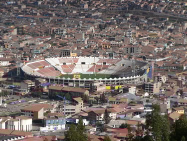 Estádio Inca Garcilaso de la Vega em Cusco, no Peru, com vista ampla das arquibancadas e gramado em dia de céu claro.