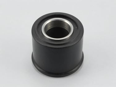Studio shot of a black rubber suspension bushing with inner metal sleeve, clean light gray background, crisp texture details.
