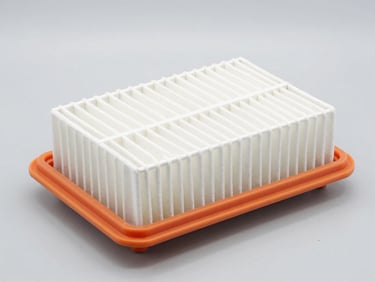 Bright studio lighting on a pristine automotive air filter with orange rubber seal on a light gray background, high-key lighting