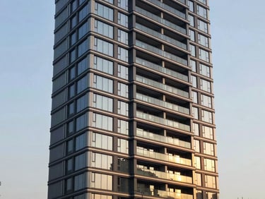 Sleek modern luxury residential tower facade with clean lines, architectural twilight photography.
